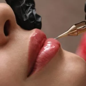 Makijaż permanentny ust – zbliżenie na usta i igłę podczas zabiegu